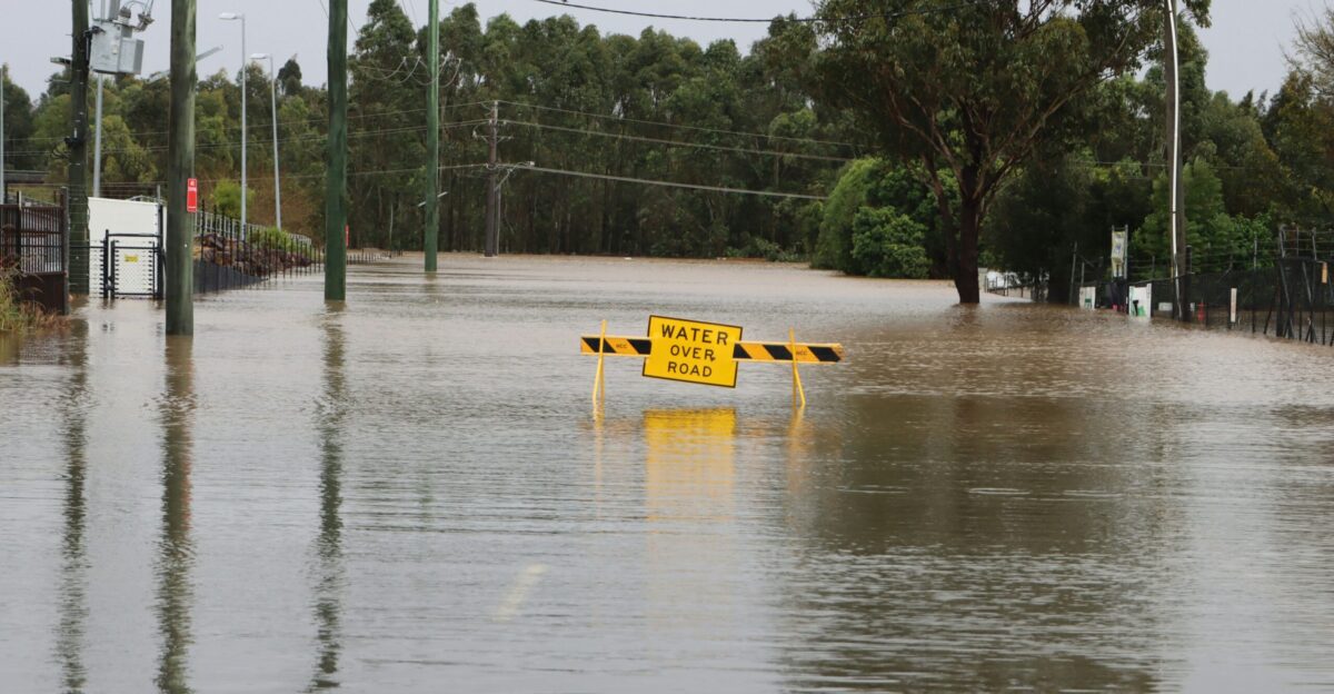 a flooded street with a yellow sign