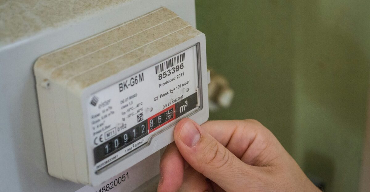 a hand holding a white box with a black and red label
