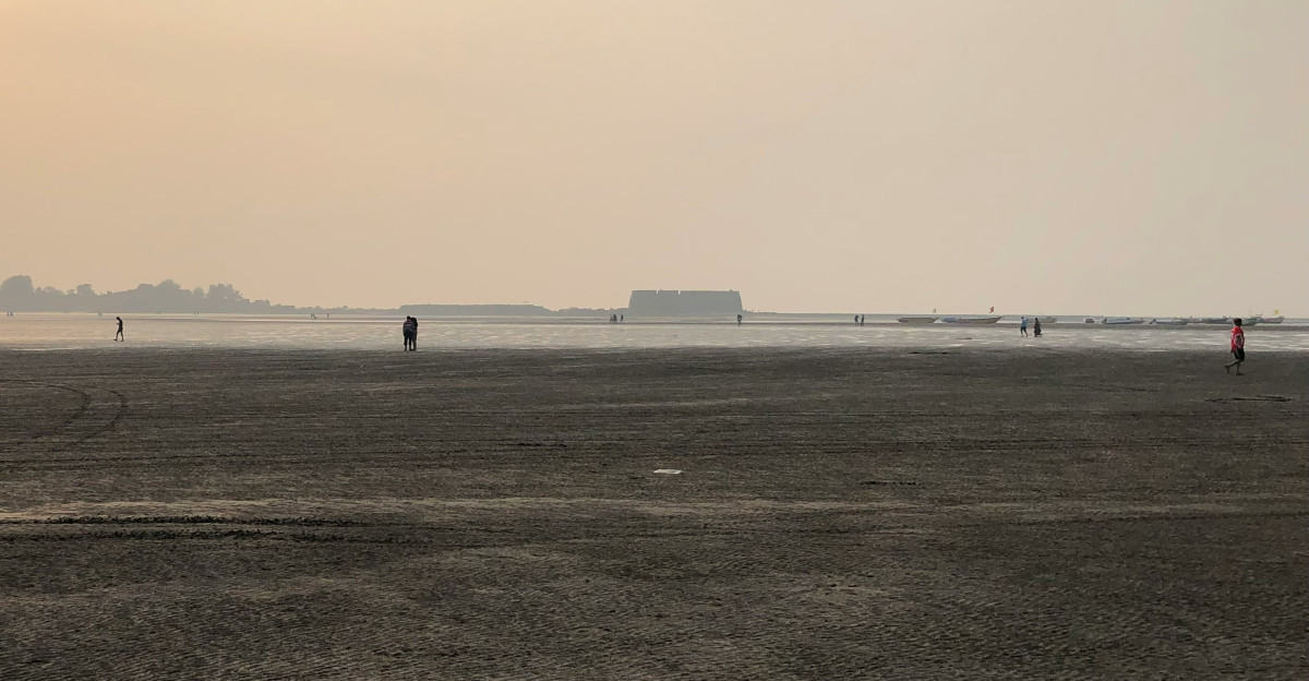 a person flying a kite on a sandy beach