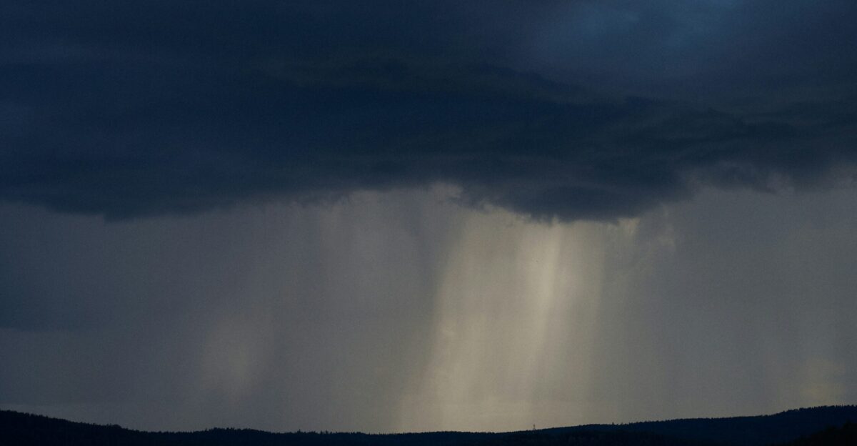 a dark sky with rain coming from the top of it