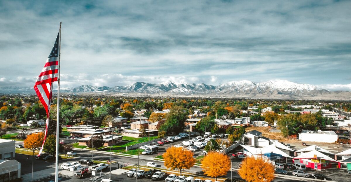 a view of a town with a large american flag in the foreground