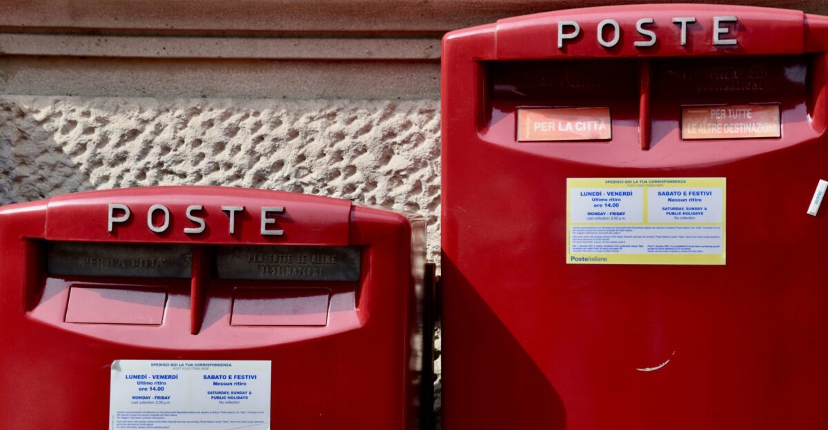 a couple of red mail boxes sitting next to each other