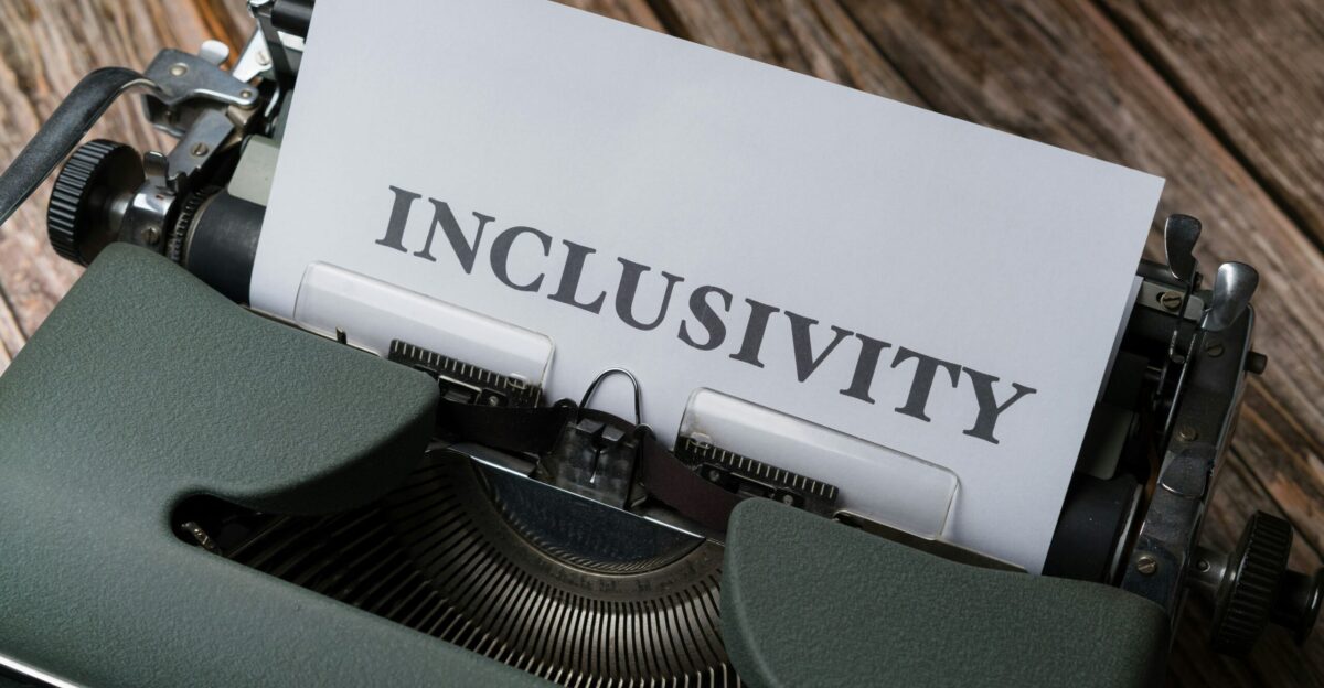 a close up of a typewriter with the word inclusivity on it
