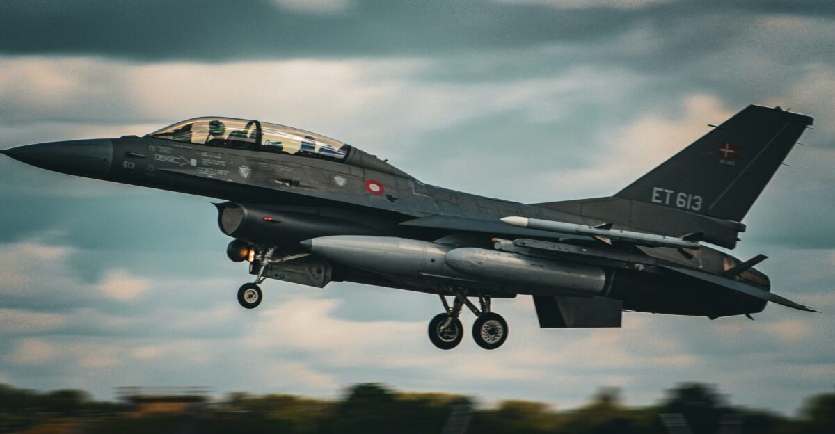 a fighter jet flying through a cloudy sky
