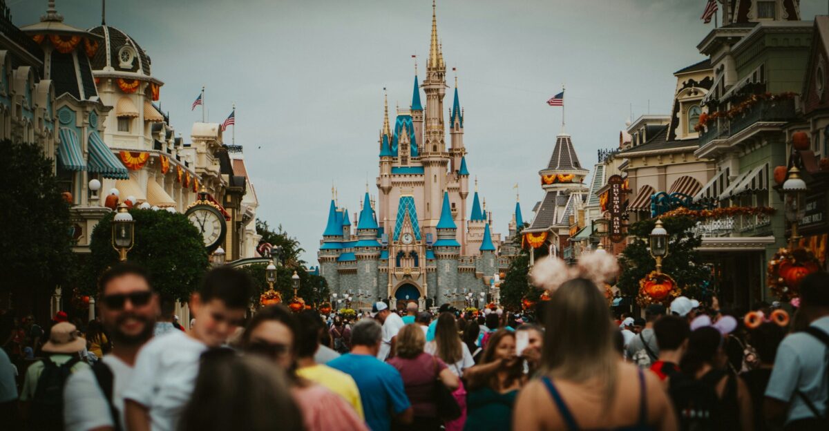 a crowd of people walking down a street in front of a castle