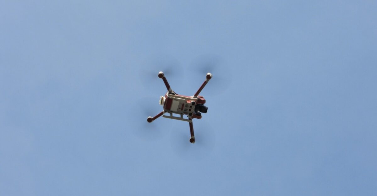 a small helicopter flying through a blue sky