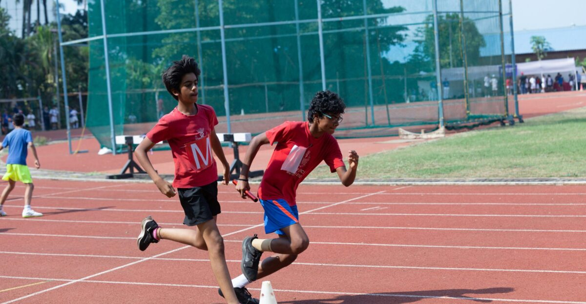 a couple of kids running around a track