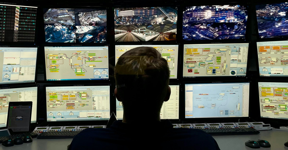 a man sitting in front of multiple monitors