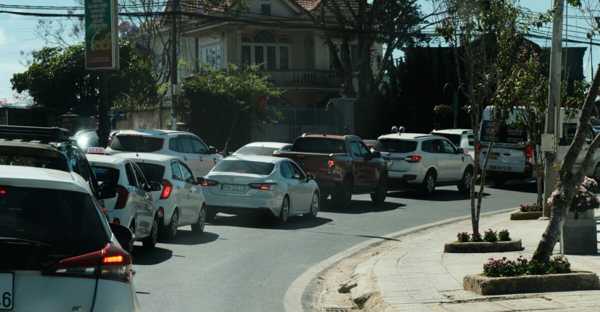 a street filled with lots of traffic next to a tall building
