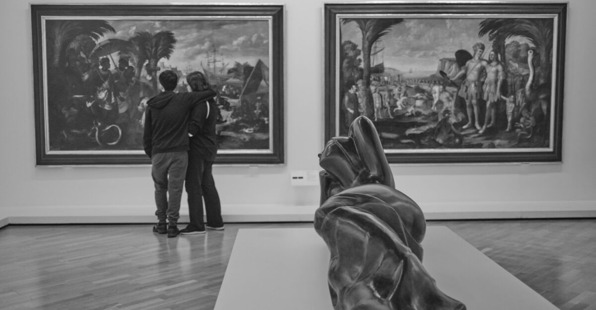a couple of people that are looking at some art