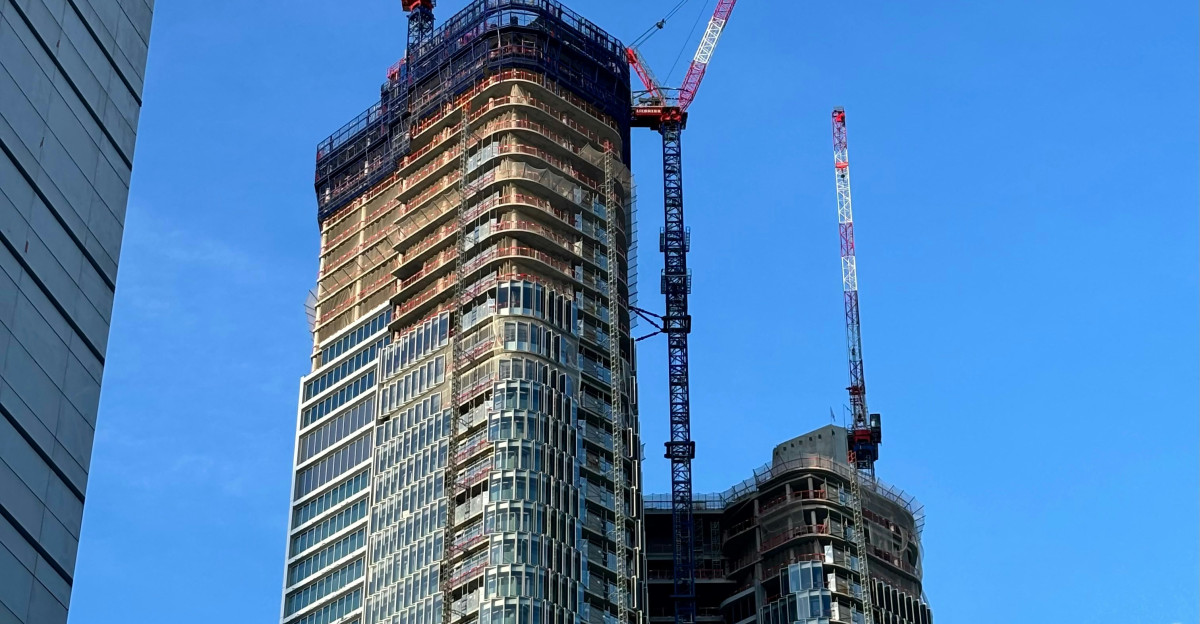 A tall building with a crane on top of it