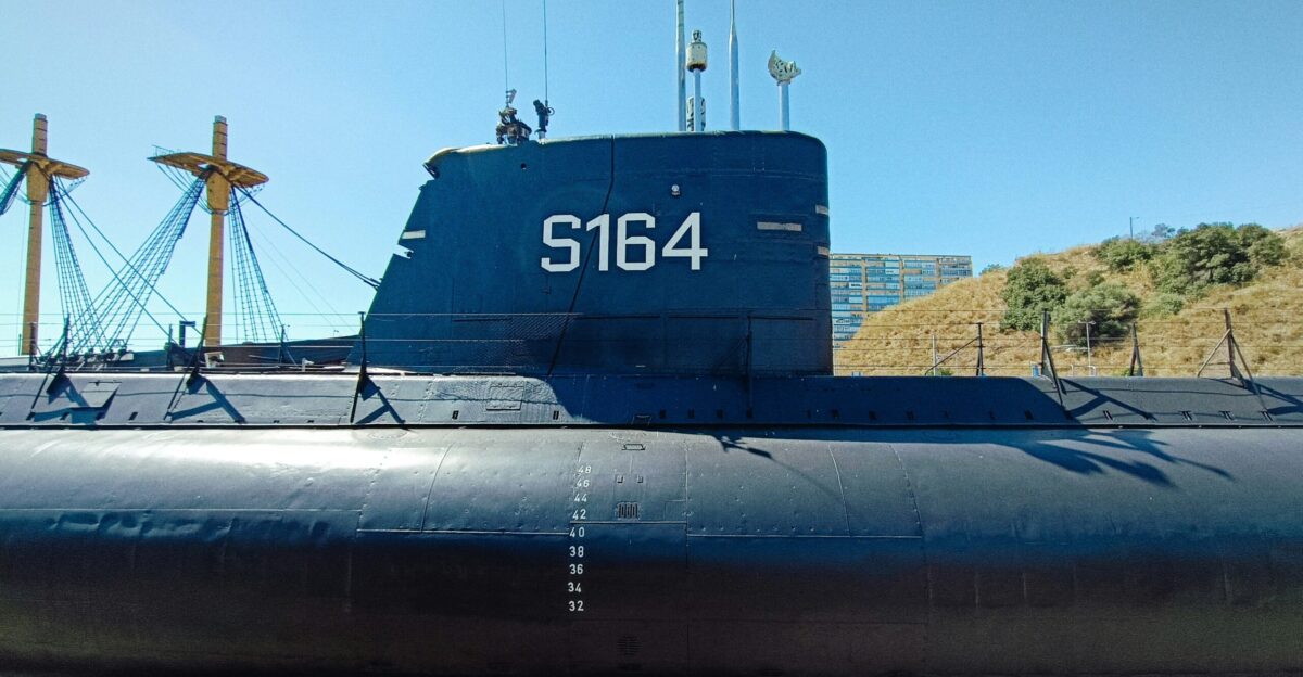 A blue and black submarine sitting on top of a wooden dock