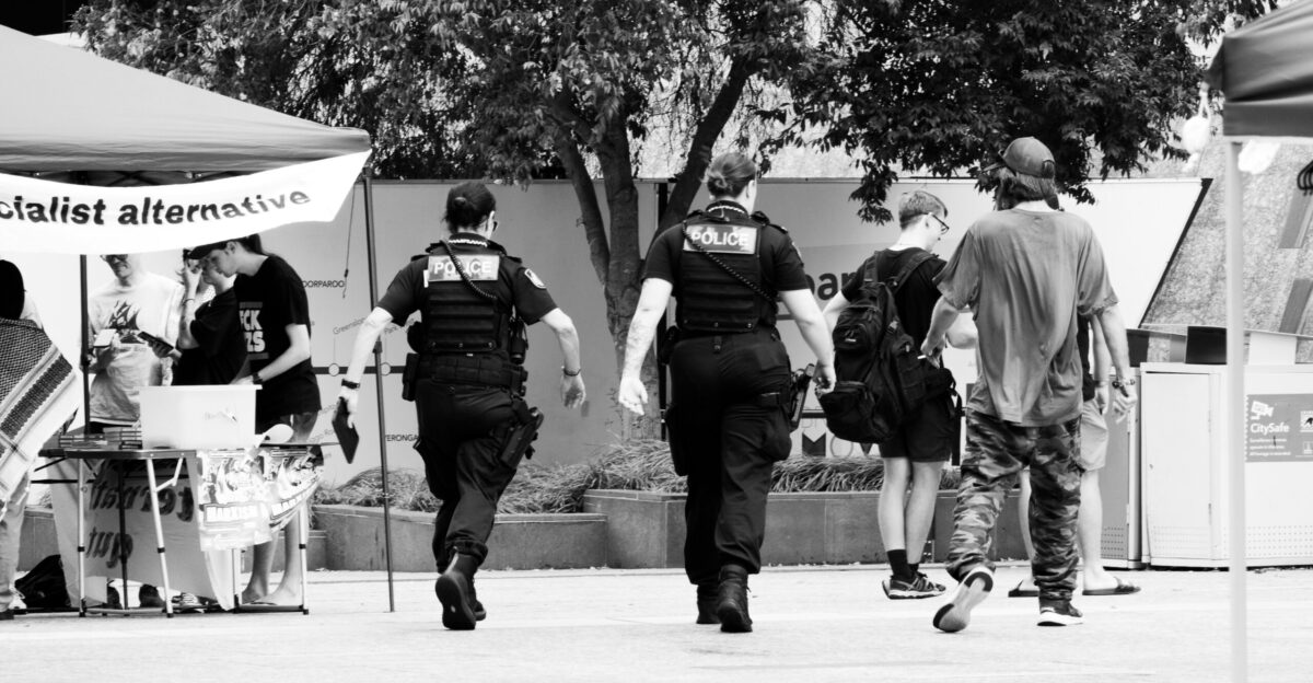 A group of people walking down a sidewalk