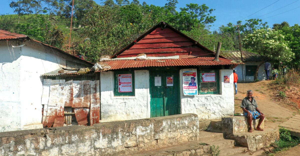A rural building stands under a bright blue sky