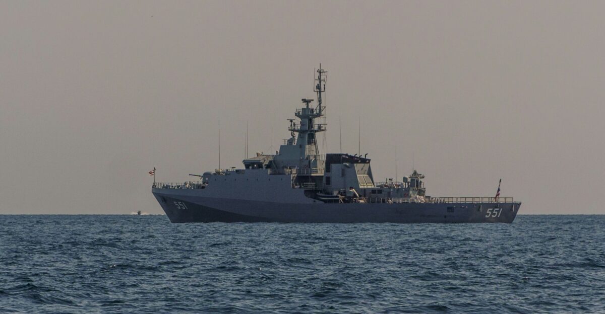 A military ship floats on calm blue waters