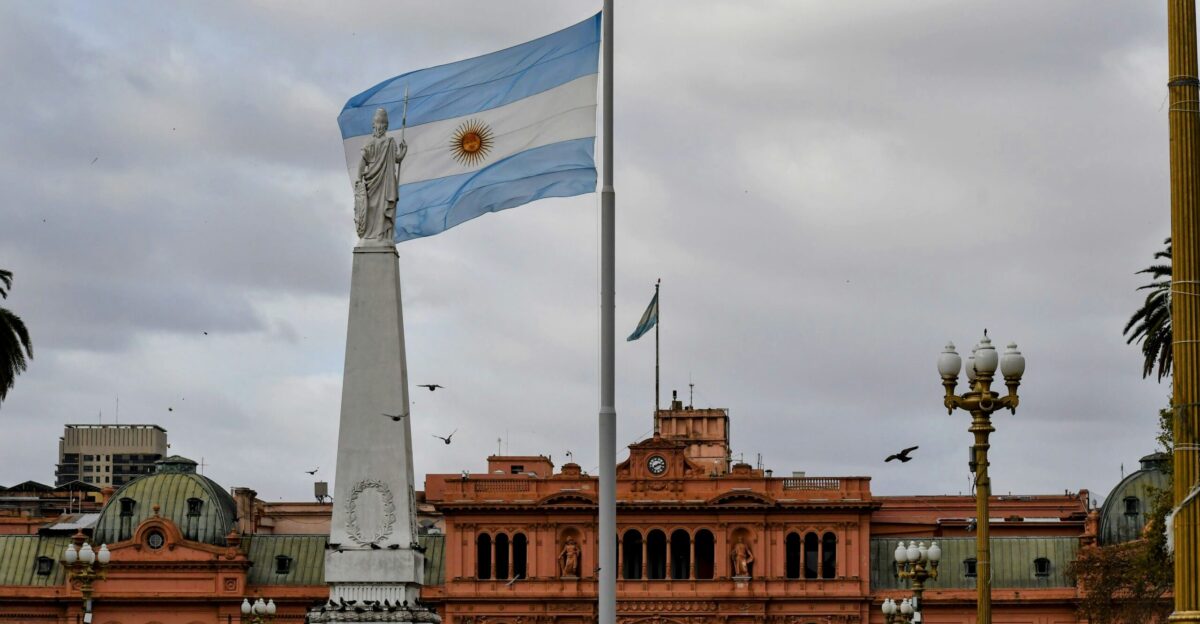 Argentinian flag waving near a prominent building