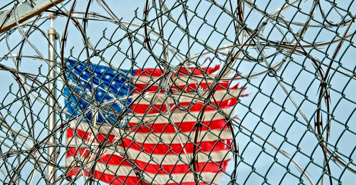 USA flag seen through barbed wire symbolizing freedom and protection