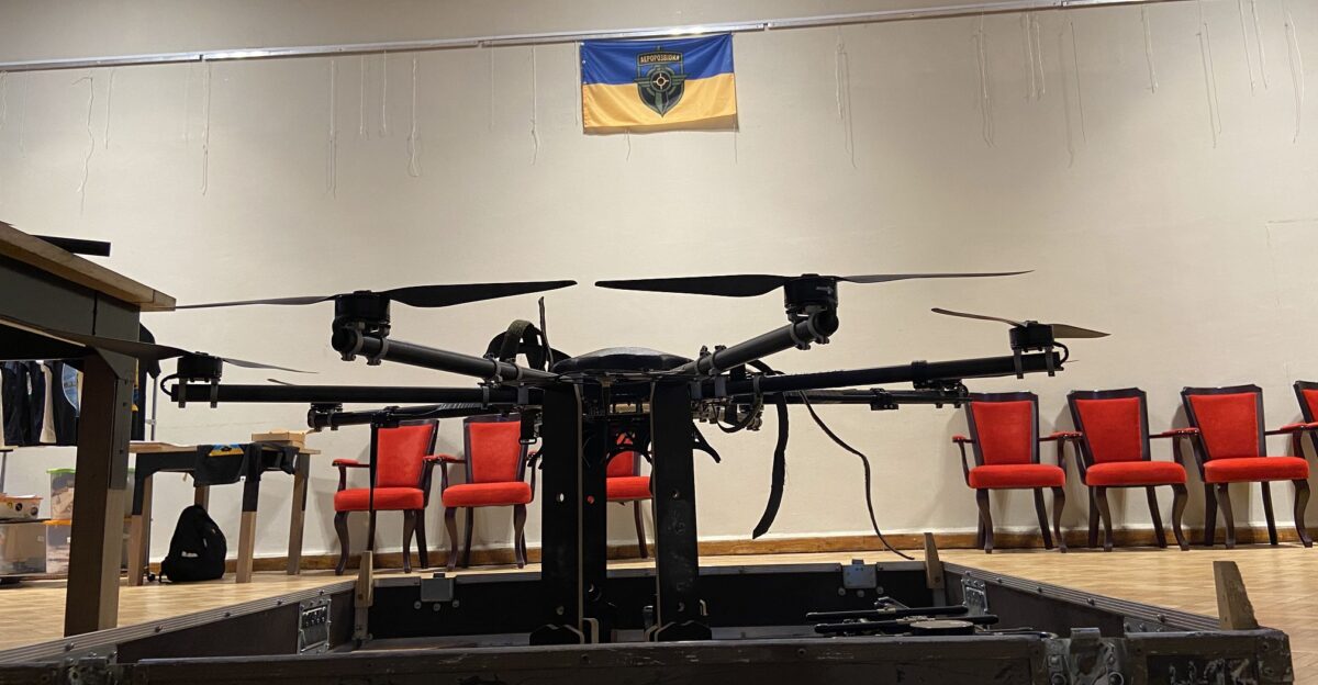 R18 drone on the exhibition at the show of the Sky Coordinator film in honor of Volodymyr Kochetkov-Sukach Organized by Aerorozvidka The Aerorozvidka flag hangs on the wall