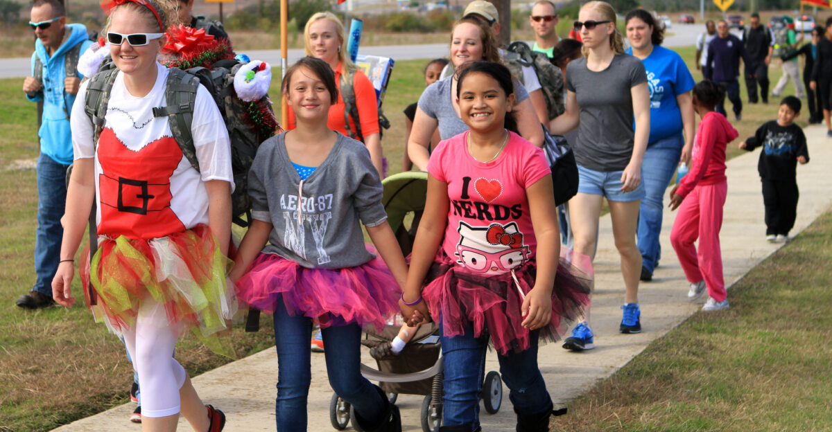 U S Soldiers and their families walk together on their way to Santa s workshop at Fort Hood Texas Nov 16 2013 More than 400 Soldiers and families from Task Force Pegasus Fires and the 1st Air Cavalry Brigade joined the Santa s Ruck March where participants walked about one mile to the workshop and dropped off their toys to be donated to Soldiers and families