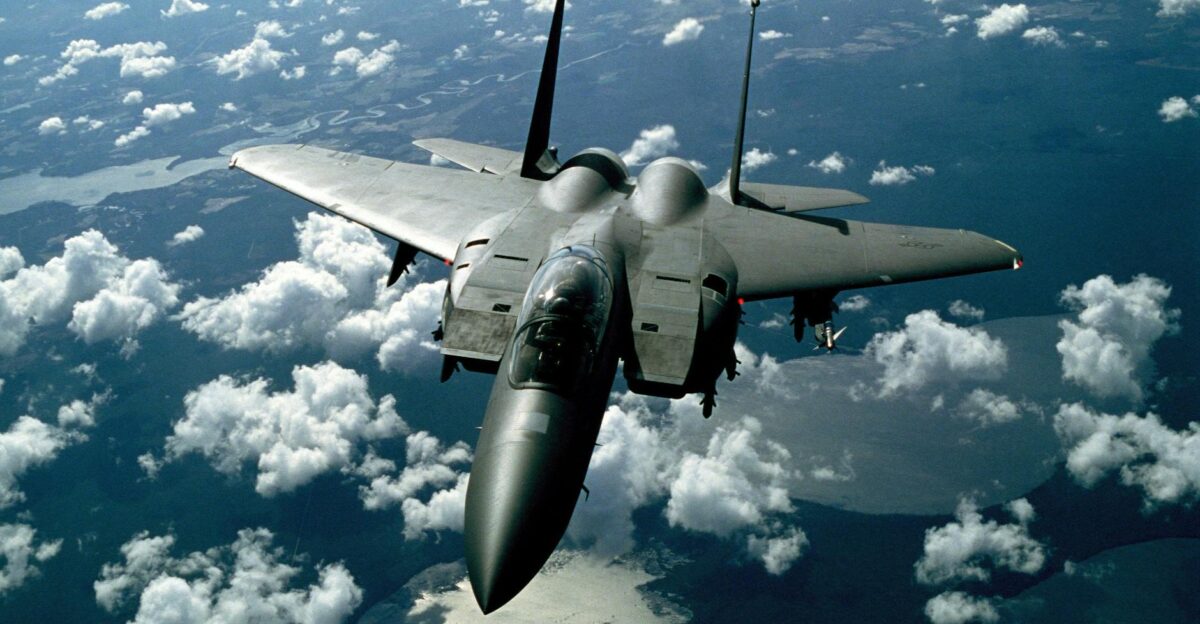 A stunning aerial view of a military fighter jet flying high above the clouds