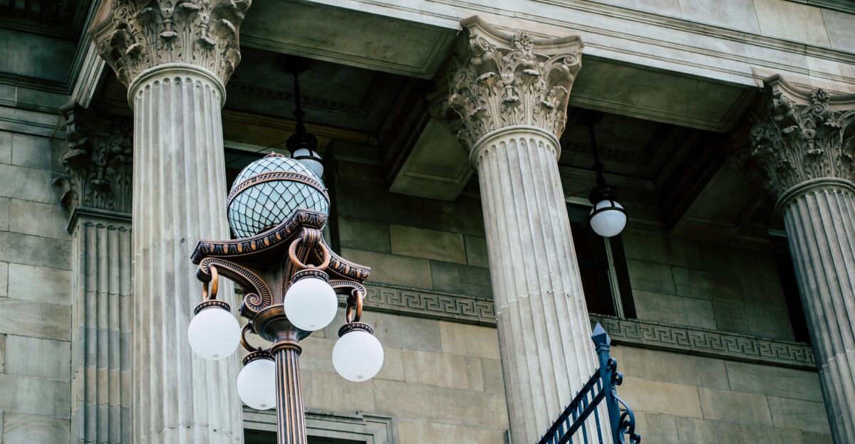 An elegant view of classic architectural columns with an antique street lamp ideal for urban landscapes