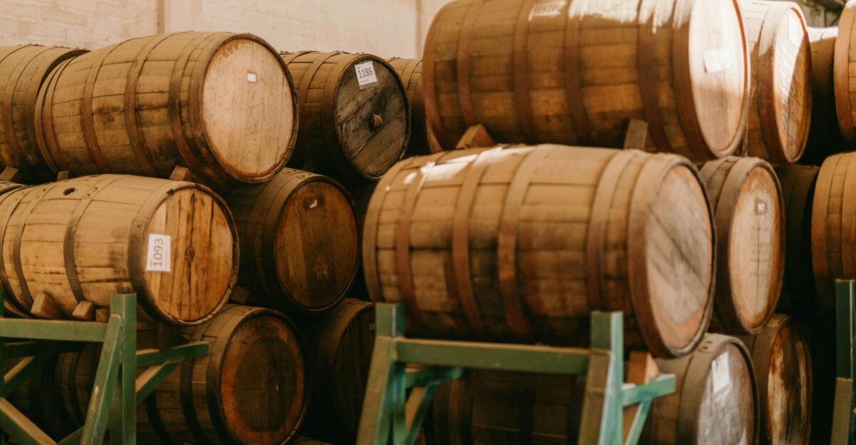 Stacked wooden barrels aging tequila in a Mexican distillery