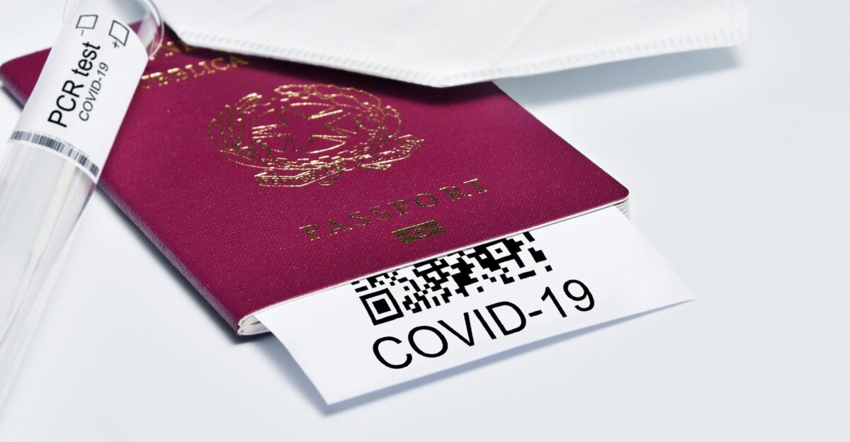 Close-up of a passport with COVID-19 test tube and face mask representing travel protocols