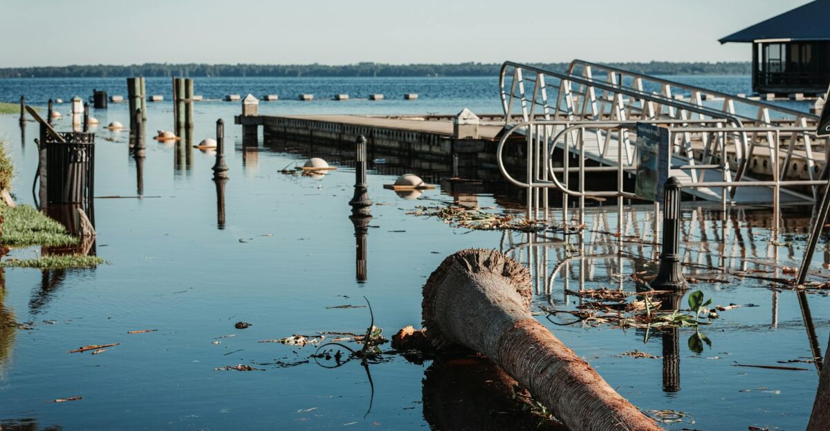 A scenic view of a flooded pier with debris and calm waters