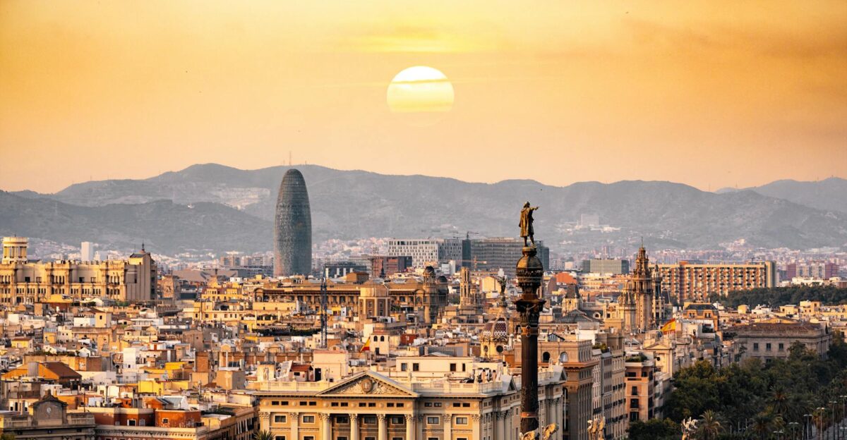 A stunning sunset view of the Barcelona skyline showcasing iconic landmarks and a warm golden hour glow
