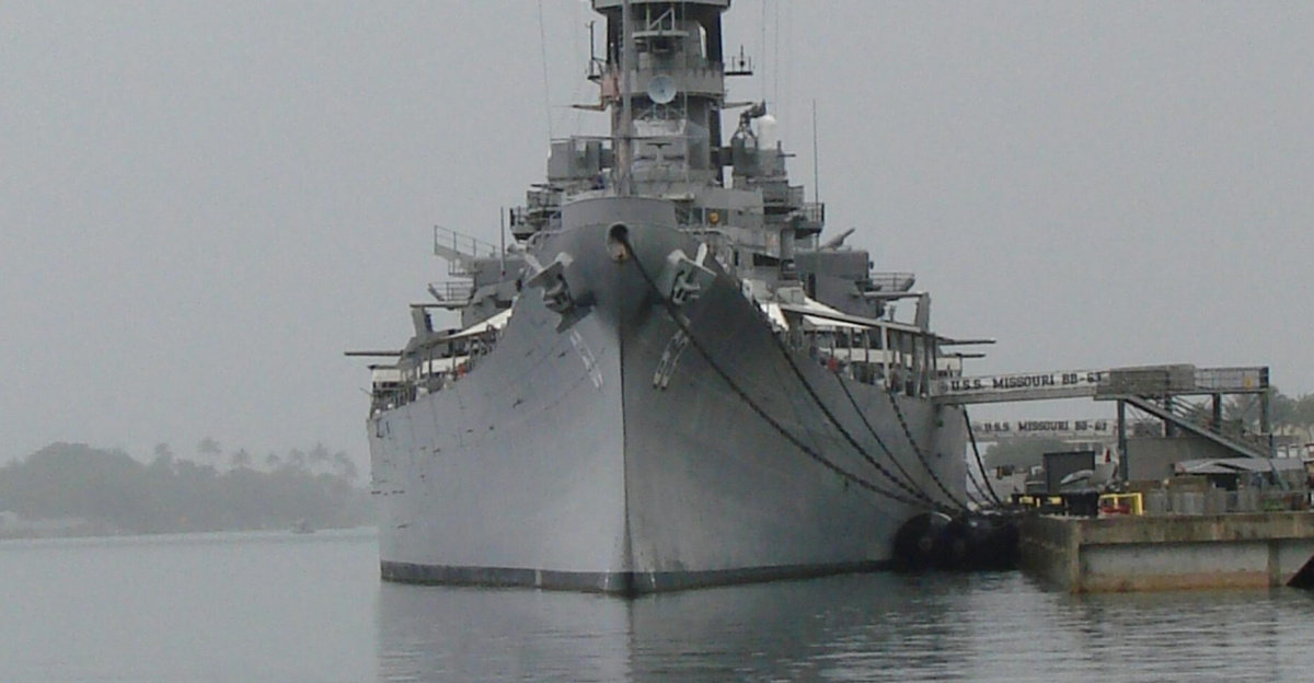 A historic battleship moored at Pearl Harbor, captured on an overcast day, symbolizing naval history.