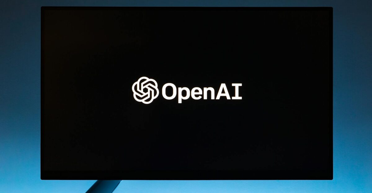 Minimalist display of OpenAI logo on a screen set against a gradient blue background