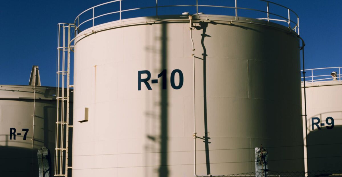 Large industrial storage tanks under blue skies highlighting metal structures