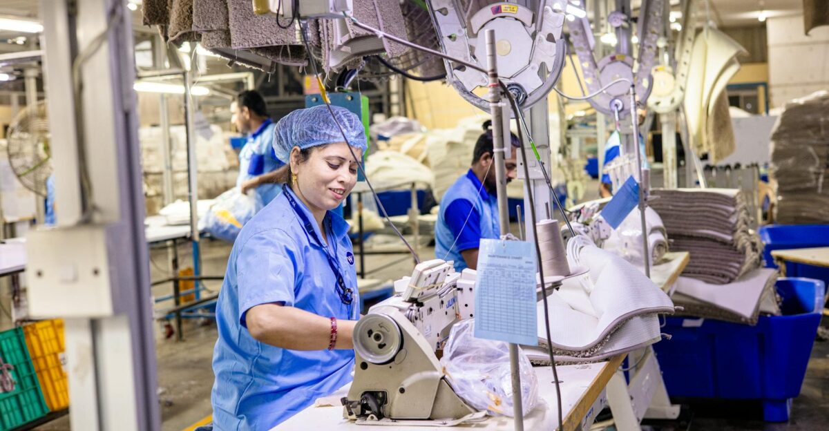 Close-up of textile factory workers operating sewing machines in an industrial setting