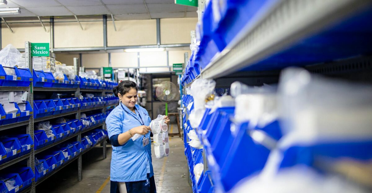 Female worker organizes shelves in a warehouse Industrial setting with labeled storage bins