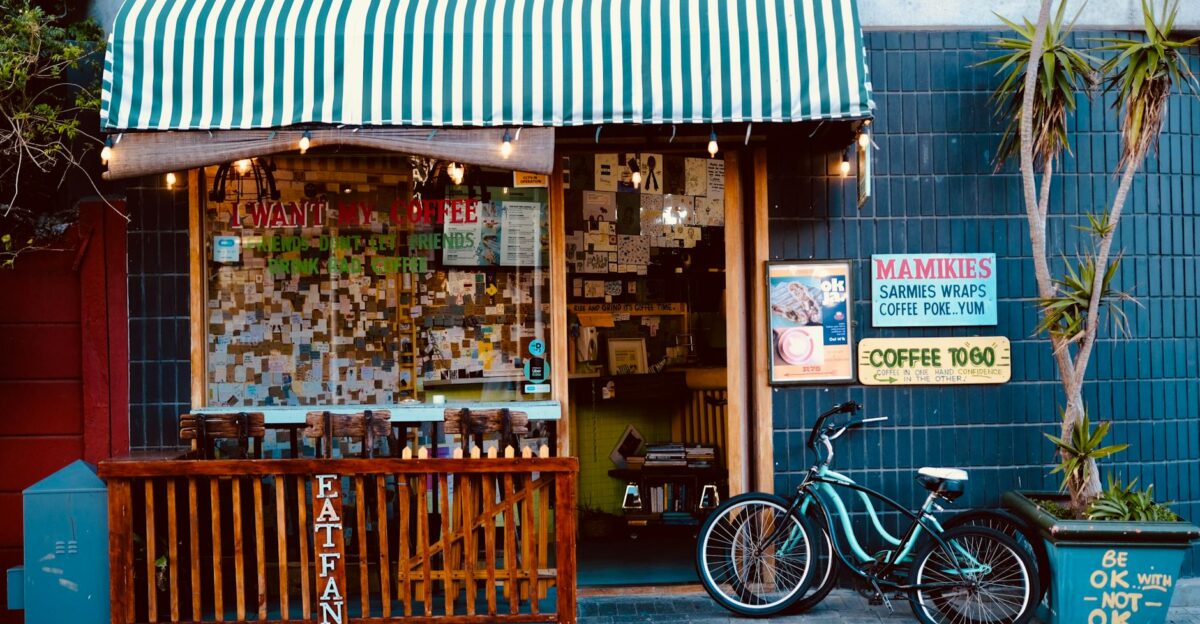 Cozy street cafe storefront with striped awning bike and eclectic signage