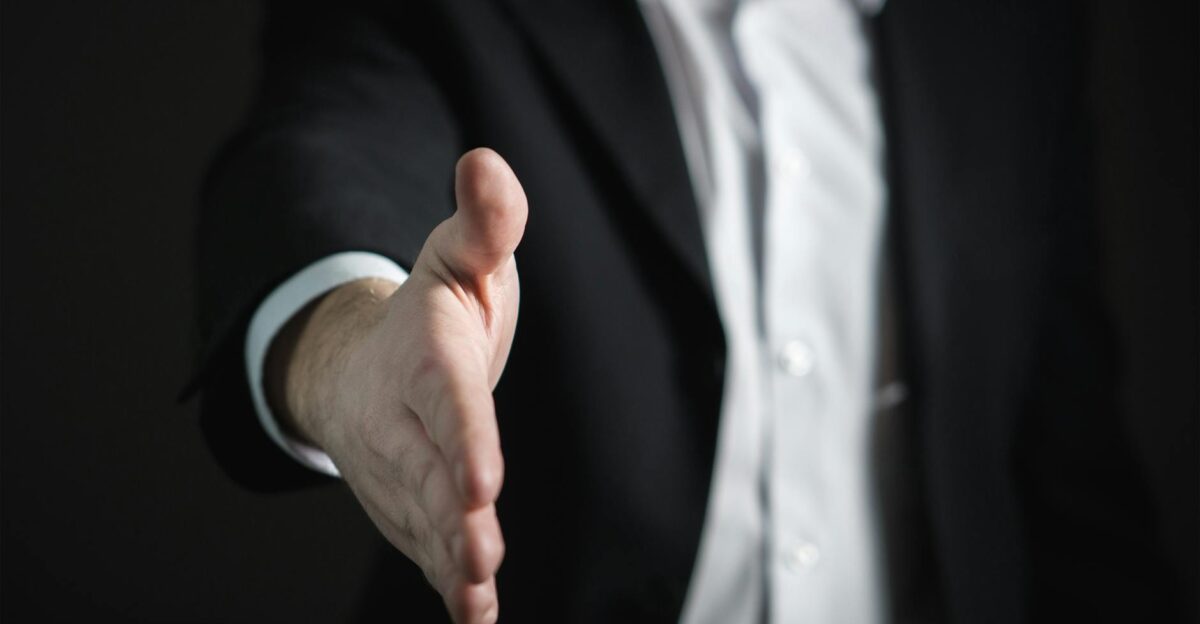 Close-up of a businessman extending hand for a handshake symbolizing agreement and partnership