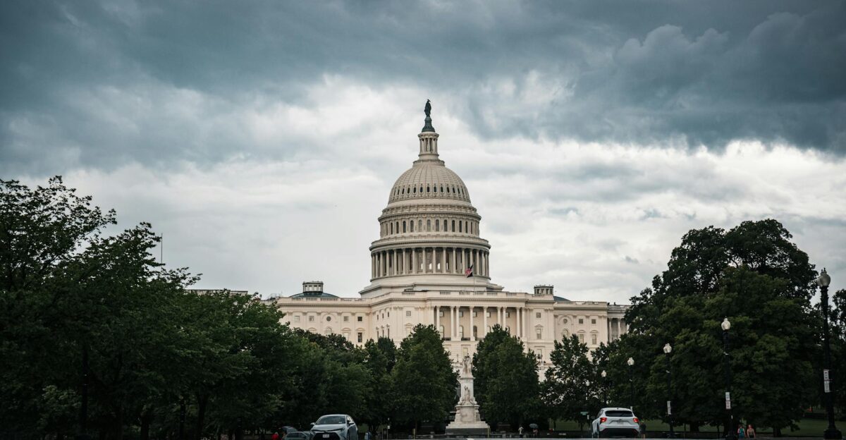 A dramatic view of the US Capitol under cloudy skies in Washington DC