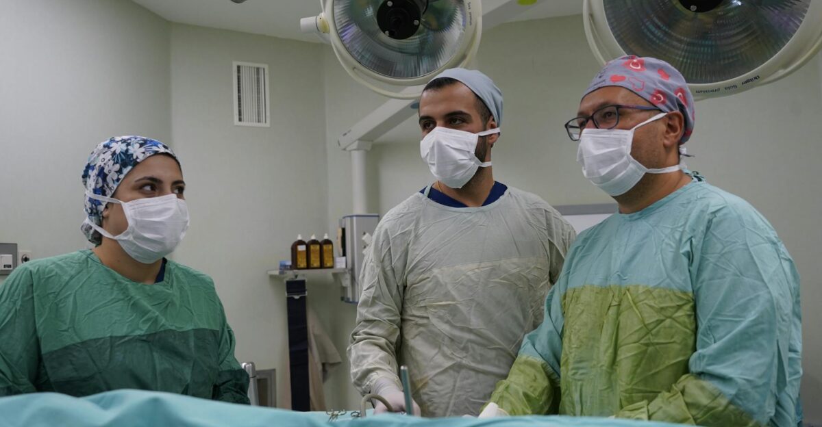 Three medical professionals focus on surgery in a hospital operating room