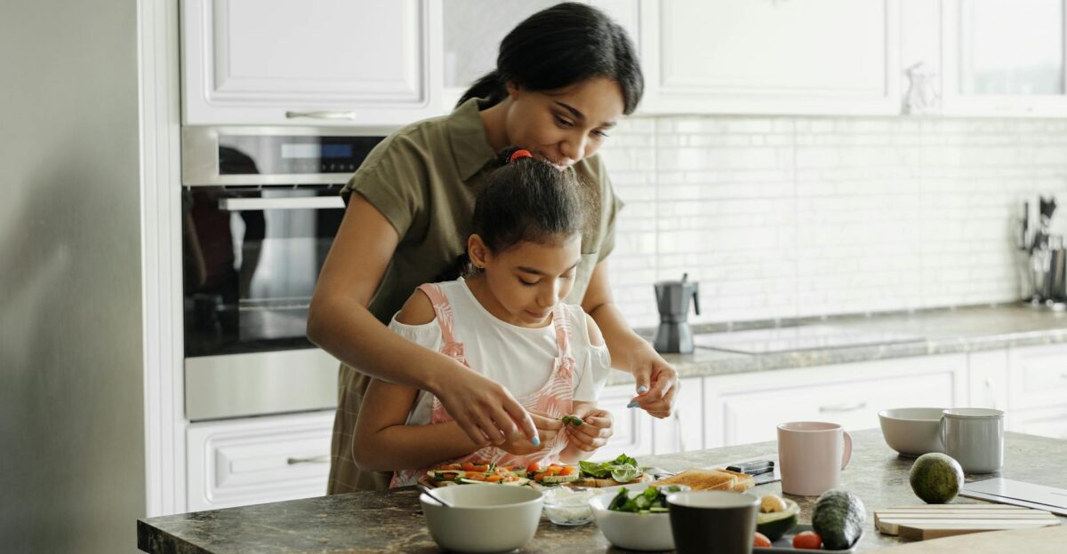 A mom and daughter share a bonding moment while preparing a healthy lunch together in the kitchen