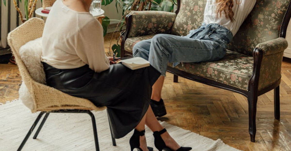 Two women engaged in a counseling session in a cozy plant-filled living room