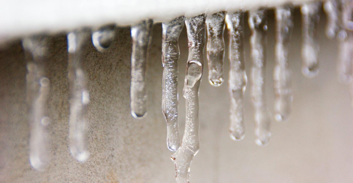 Detailed macro shot of clear icicles hanging against a blurred background