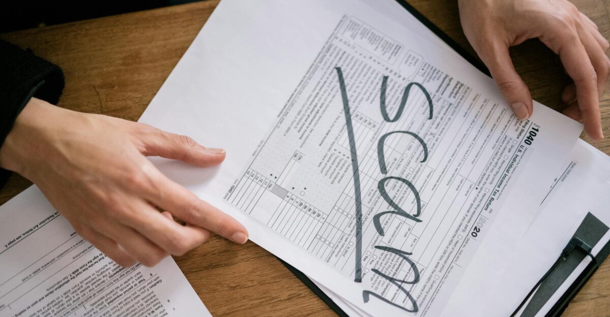 Documents highlighting tax fraud with the word scam on tax forms