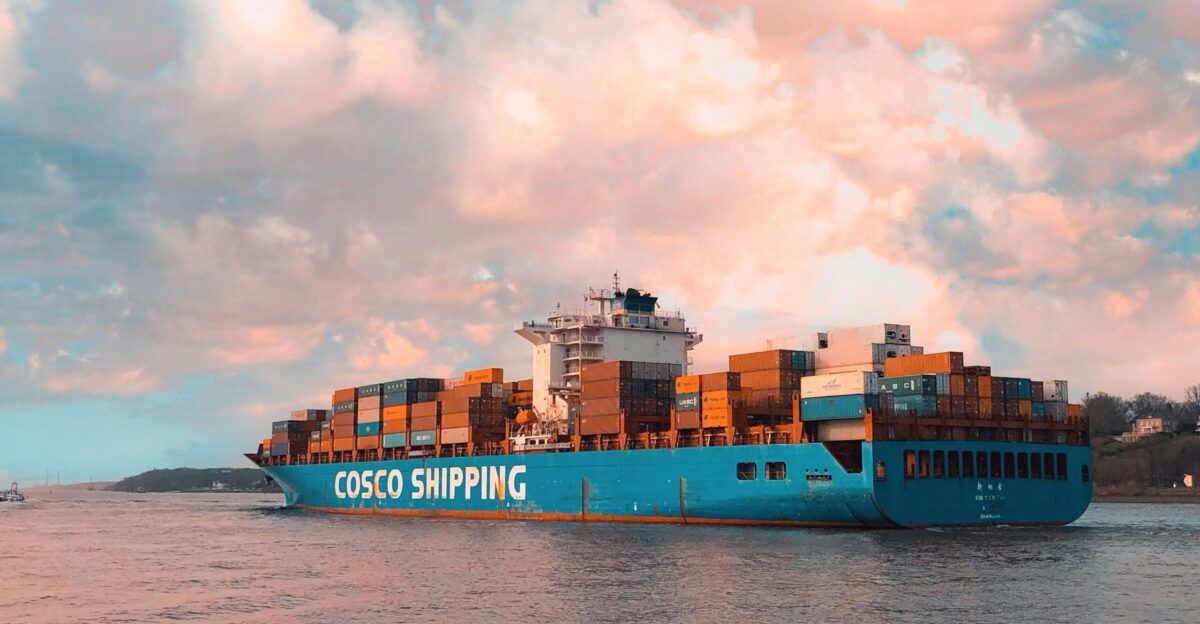 blue cargo ship on sea under cloudy sky during daytime