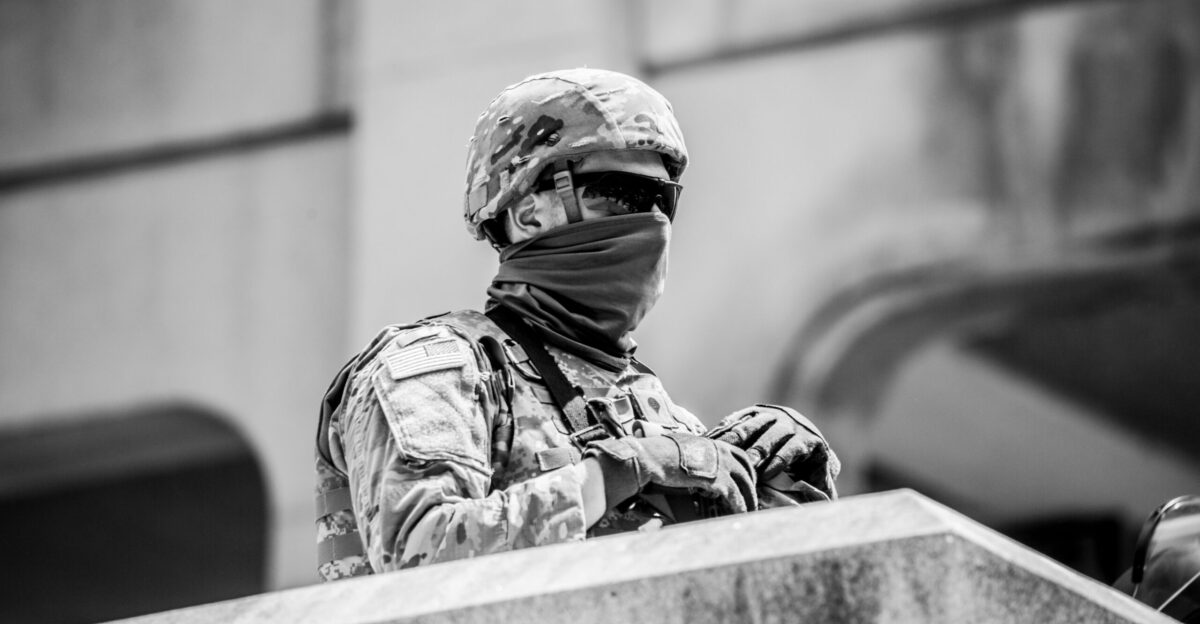 grayscale photo of man in camouflage uniform