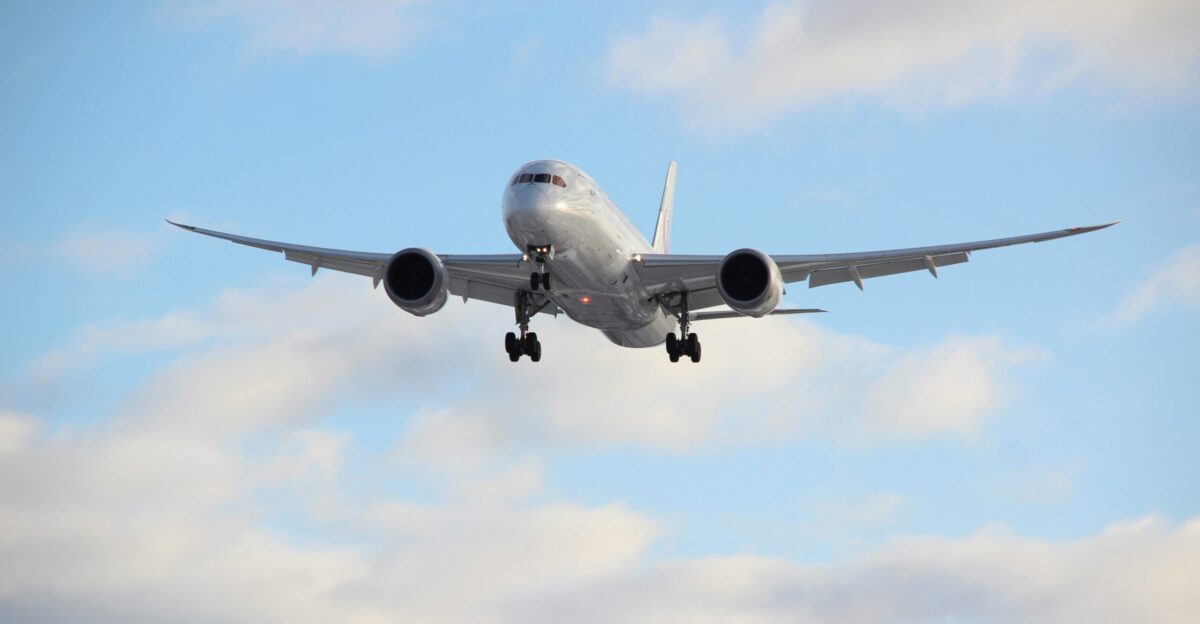 white passenger plane in mid air during daytime