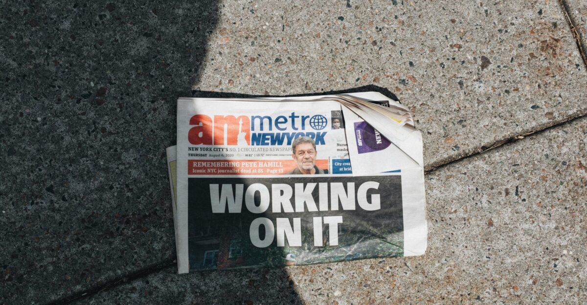 a newspaper laying on the ground next to a bag