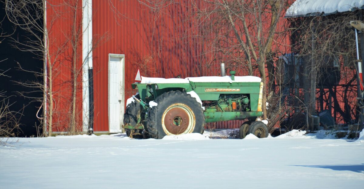 green and black tractor on snow covered ground