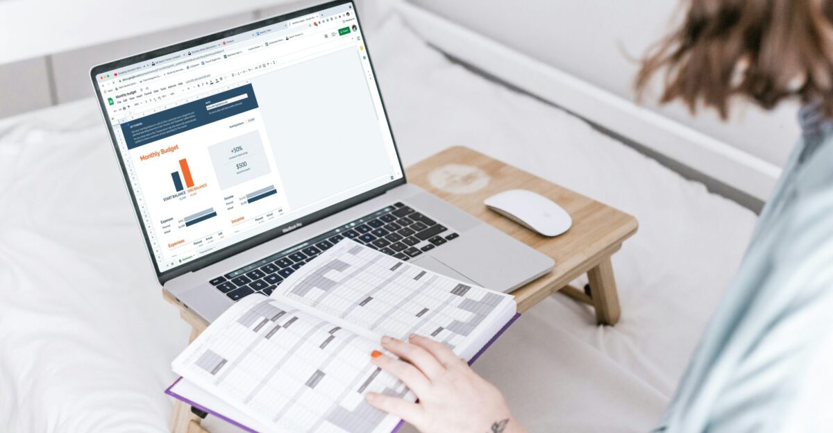 a person sitting on a bed with a laptop