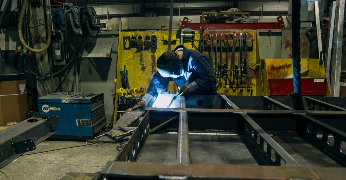 a man in a factory working on a piece of metal