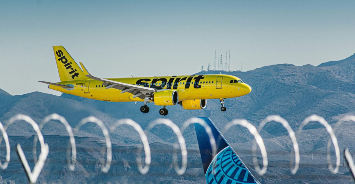 a yellow and blue jet airliner taking off from an airport